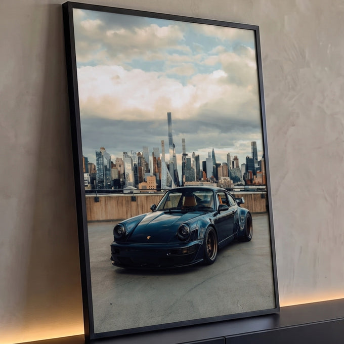 Porsche 911 preto com rodas bronze diante do skyline de Nova York sob céu nublado, quadro decorativo