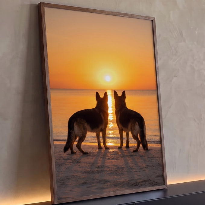 Dois pastores alemães em silhueta olhando o pôr do sol laranja sobre o mar na praia, quadro decorativo
