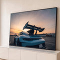 Quadro Decorativo Grande Carro Automóvel para Sala Azul | quadros decorativos para sala | carro esportivo azul claro com aerofólio preto contra céu de pôr do sol | Porao dos Quadros