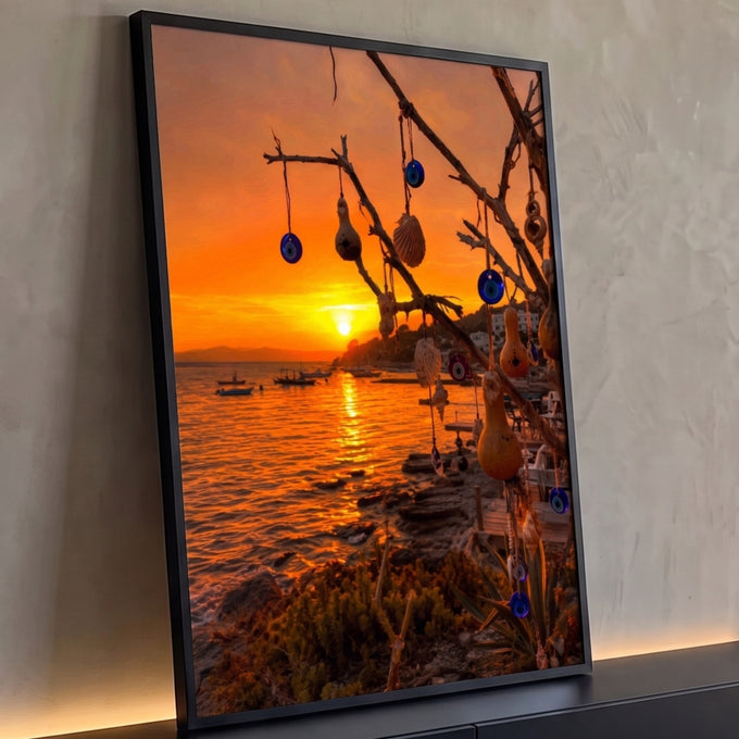 Pôr do sol laranja sobre o mar com galho de amuletos olho grego, cabaças e conchas, quadro decorativo