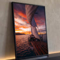 Barco à vela com velas brancas e convés de madeira navegando no mar ao pôr do sol laranja, quadro decorativo