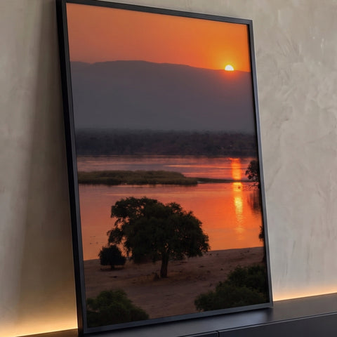 Pôr do sol laranja sobre rio africano com acácia e antílopes na margem, quadro decorativo