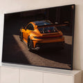 Quadro Decorativo Grande Carro Automotivo para Sala | quadros decorativos para sala | carro esportivo laranja metálico visto de trás com aerofólio e luz lateral forte | Porao dos Quadros