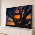 Árvore com galhos em forma de coração emoldurando pôr do sol sobre montanhas e rio, quadro decorativo