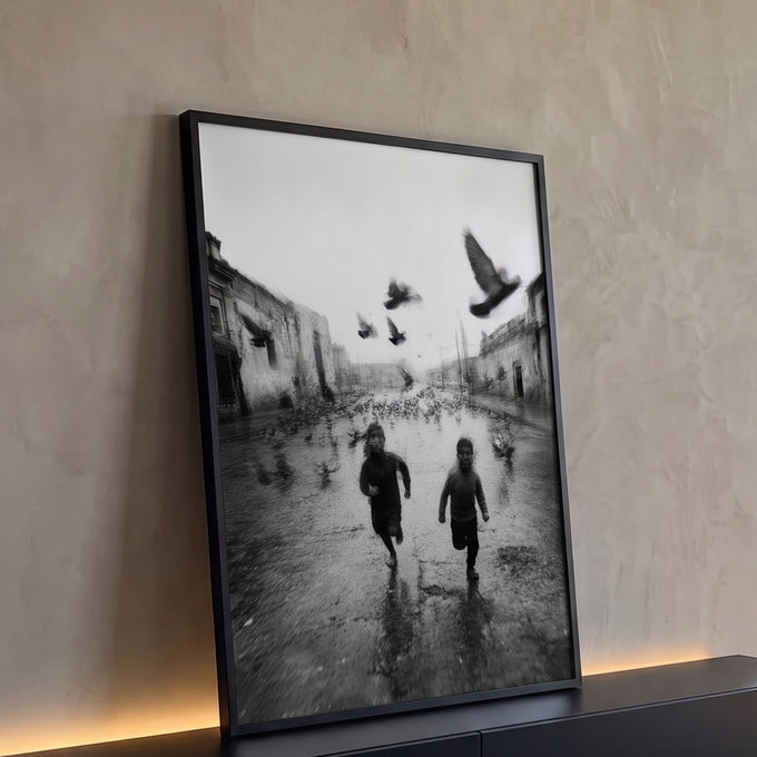 Fotografia preto e branco de dois meninos correndo entre pombos em rua antiga molhada, quadro decorativo