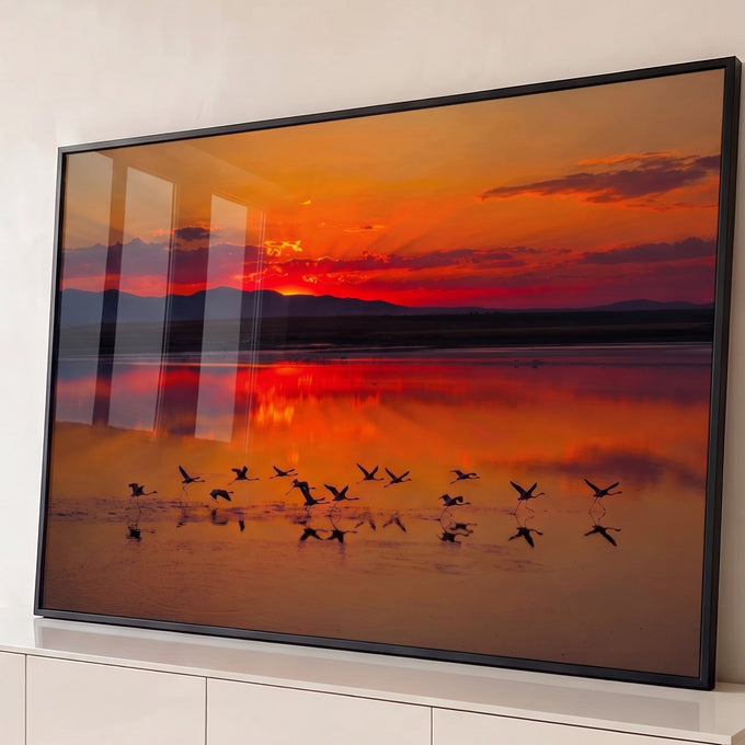 Quadro Decorativo Grande Flamingos Alçando para Sala Laranja | quadros decorativos para sala | flamingos em silhueta alçando voo sobre lago durante pôr do sol vermelho e laranja | Porao dos Quadros