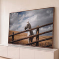 Cavalo branco atrás de cerca de madeira rústica, colinas secas e céu nublado ao fundo, quadro decorativo