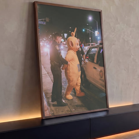 Personagem de fantasia amarela algemado por policiais ao lado de viatura à noite, quadro decorativo