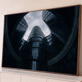 Prédios de vidro curvos em espiral vistos de baixo sob céu nublado, em tons azul-escuros, quadro decorativo