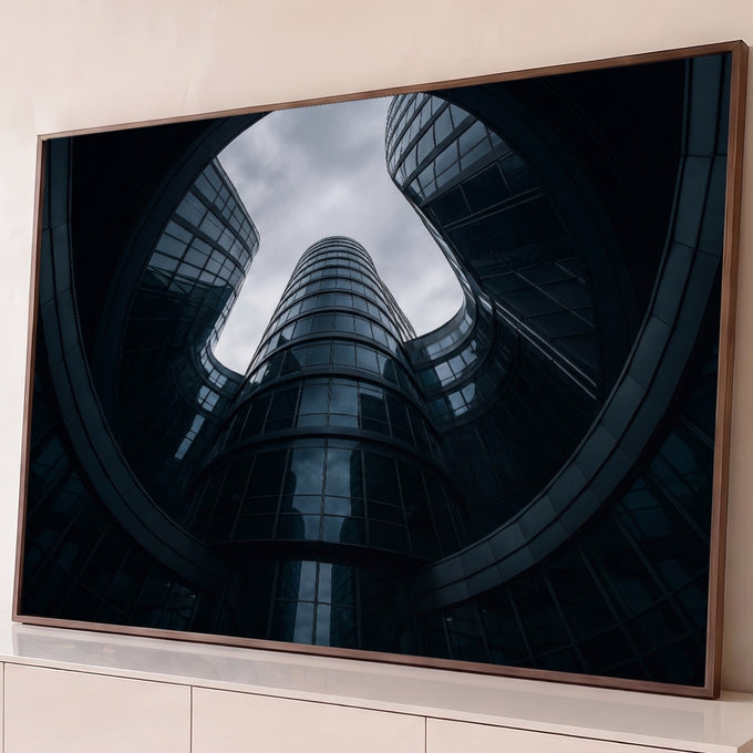 Prédios de vidro curvos em espiral vistos de baixo sob céu nublado, em tons azul-escuros, quadro decorativo