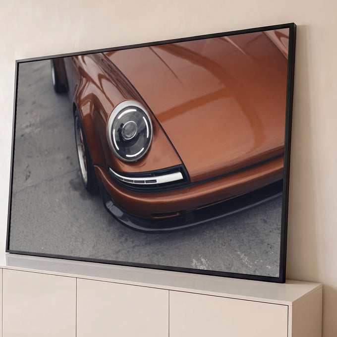Close do farol redondo com LED de Porsche clássico cor cobre sobre asfalto cinza, quadro decorativo