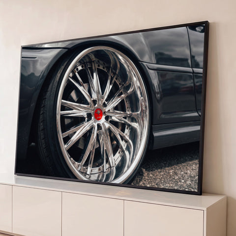 Fotografia em close de roda esportiva cromada com centro vermelho em carro cinza, quadro decorativo