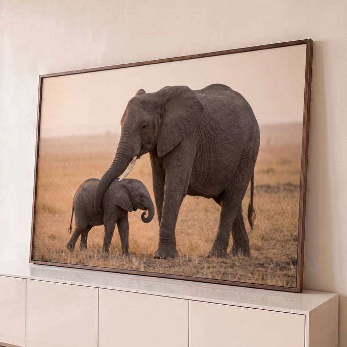 Quadro Decorativo Grande Elefanta e Filhote para Sala Bege | quadros decorativos para sala | elefanta envolve filhote com a tromba em savana ao entardecer | Porao dos Quadros
