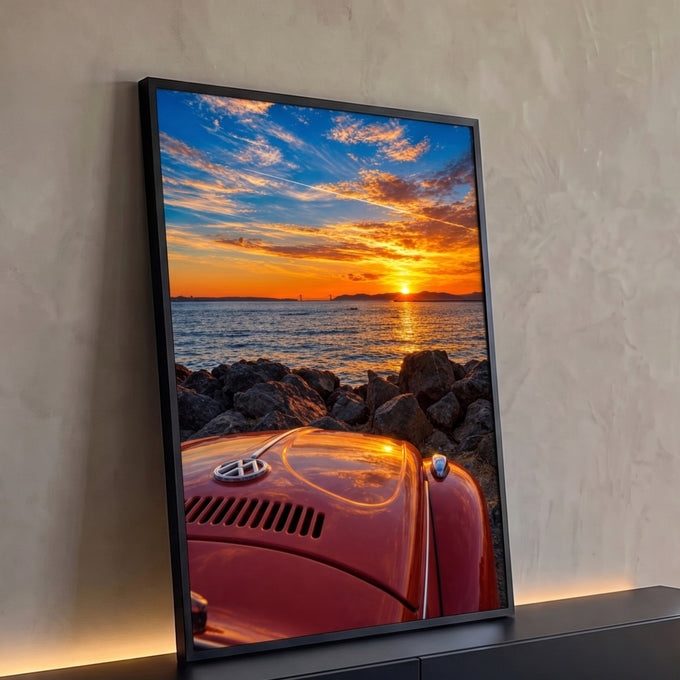 Capô de Fusca antigo laranja diante do mar, pedras e pôr do sol com ponte ao fundo, quadro decorativo