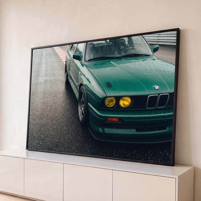 BMW M3 E30 verde com faróis amarelos e gotas de chuva parado na pista de corrida, quadro decorativo