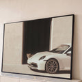 Quadro Decorativo Grande Carro Esportivo para Sala Branco | quadros decorativos para sala | carro esportivo branco estacionado com filhote de leão espiando de uma porta escura | Porao dos Quadros
