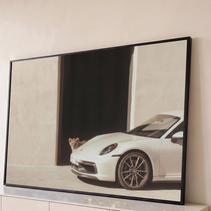 Quadro Decorativo Grande Carro Esportivo para Sala Branco | quadros decorativos para sala | carro esportivo branco estacionado com filhote de leão espiando de uma porta escura | Porao dos Quadros