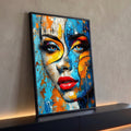 Rosto de mulher com textura craquelada em azul e laranja, olhos azuis e batom vermelho, quadro decorativo
