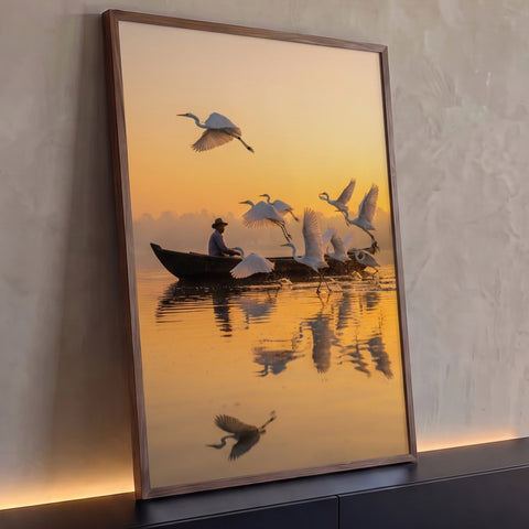 Garças brancas voando sobre lago dourado ao amanhecer com pescador em barco, quadro decorativo
