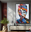Rosto de mulher em grafite com padrões azuis e vermelhos sobre tijolos, quadro decorativo