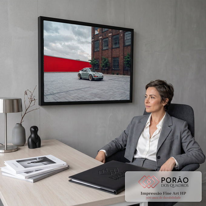 Porsche 911 verde sage em pátio de pedra diante de prédio de tijolos e muro vermelho, quadro decorativo