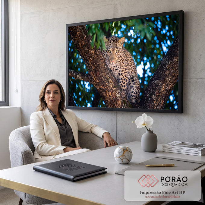Leopardo com olhar fixo entre troncos de árvore, com folhagem e luz azul desfocada, quadro decorativo