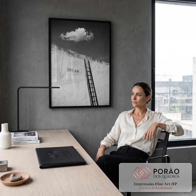 Escada encostada em muro branco com a palavra Dream e nuvem no céu escuro, preto e branco, quadro decorativo