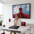 Quadro Decorativo Grande Mulher de Capa para Sala Vermelho | quadros decorativos | figura com rosto branco e capa vermelha diante de nuvens volumosas no céu azul | em ambiente 2 | Porao dos Quadros