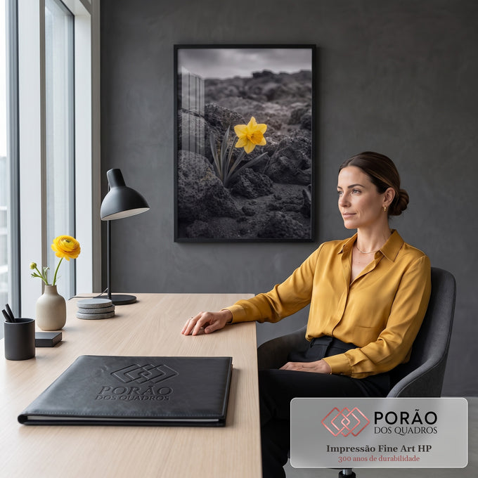 Narciso amarelo solitário entre rochas vulcânicas pretas sob céu nublado, cor seletiva, quadro decorativo