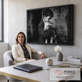 Fotografia preto e branco de menino de cabelos cacheados abraçando um cordeiro branco, quadro decorativo