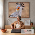 Close de pássaro serpentário com penas cinza, crista preta e rosto laranja em fundo bege, quadro decorativo