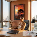 Árvore inclinada em silhueta sobre colinas com sol baixo e céu laranja no pôr do sol, quadro decorativo