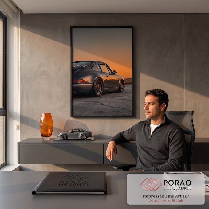 Porsche 911 cinza rebaixado com rodas douradas sob céu laranja de pôr do sol, quadro decorativo
