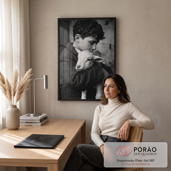 Fotografia preto e branco de menino de cabelo cacheado abraçando um cordeiro, quadro decorativo