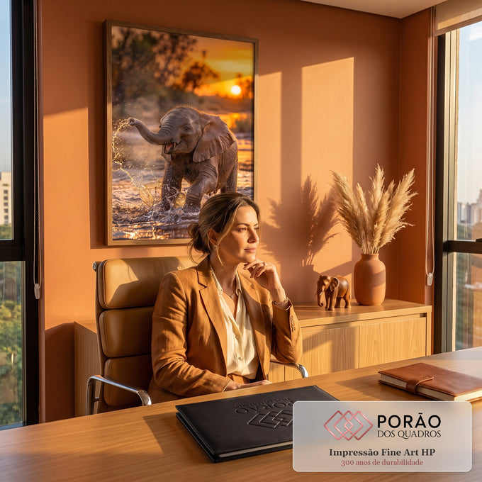 Quadro Decorativo Filhote de Elefante na Água ao Pôr do Sol | quadros decorativos | filhote de elefante espirrando água com a tromba sob pôr do sol dourado | em ambiente 2 | Porao dos Quadros