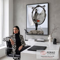 Mulher de casaco geométrico diante de espelho com rosto gigante e garça sobre rochas, quadro decorativo