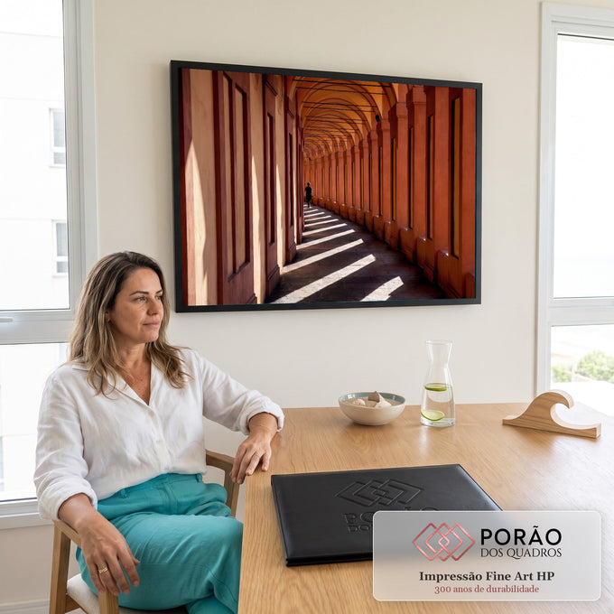 Corredor de arcos em Bolonha, tons terracota, sombras diagonais e pessoa caminhando, quadro decorativo
