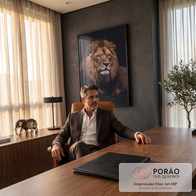 Fotografia de leão deitado com juba volumosa e olhos âmbar sobre fundo preto, quadro decorativo