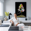 Rosto surreal em perfil com olho verde gigante, casas coloridas, escada e pernas listradas, quadro decorativo