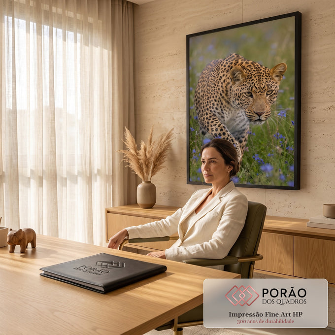 Leopardo agachado à espreita, olhar intenso, em campo verde com flores lilás, quadro decorativo