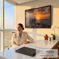 Farol sobre rochas ao pôr do sol com vila branca, veleiros e barcos de pesca no mar, quadro decorativo