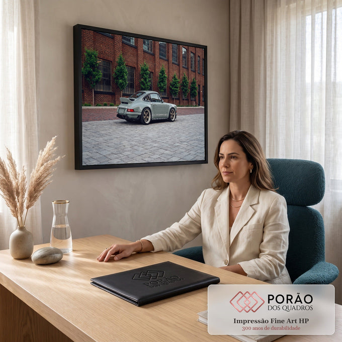 Porsche 911 clássico cinza com rodas douradas em rua de paralelepípedos e prédio de tijolos, quadro decorativo