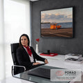 Porsche 911 laranja estacionado à beira-mar com skyline da cidade e céu com nuvens, quadro decorativo