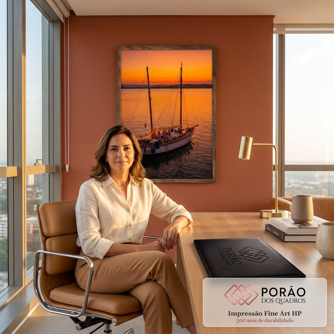 Veleiro com luzes e pessoas no convés navegando em mar calmo sob pôr do sol laranja, quadro decorativo