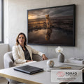 Filhote de leão na savana de terra rachada vendo o reflexo de um leão adulto na água, quadro decorativo