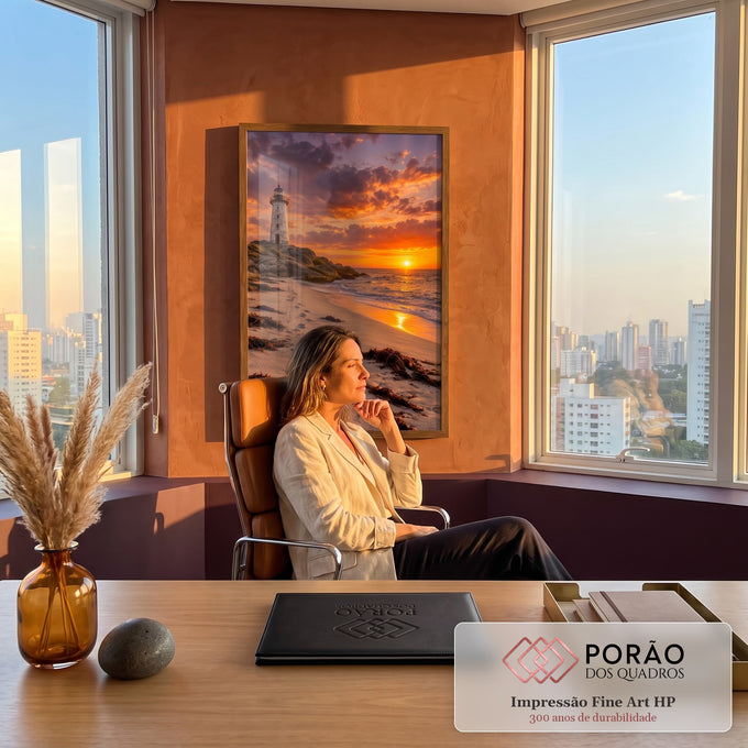 Farol branco sobre rochas, praia com pegadas e algas e pôr do sol laranja no mar, quadro decorativo