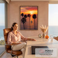 Pôr do sol laranja no mar com palmeiras altas em silhueta e veleiro branco ao centro, quadro decorativo