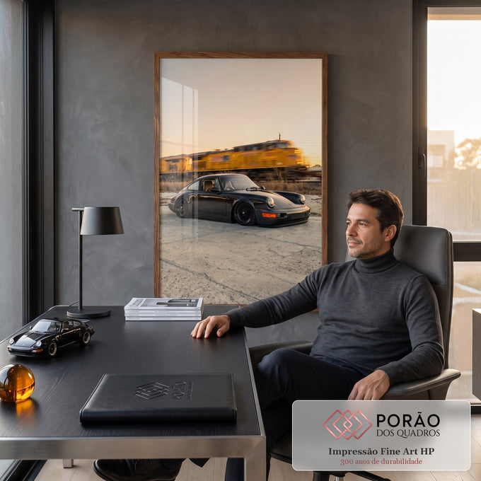 Porsche 911 preto rebaixado com trem amarelo desfocado ao fundo no pôr do sol, quadro decorativo