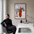 Mulher de casaco vermelho, chapéu pontudo e máscara ao lado de zebra em deserto branco, quadro decorativo