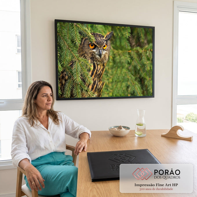 Coruja-real de olhos laranja intensos escondida entre galhos verdes de pinheiro, quadro decorativo